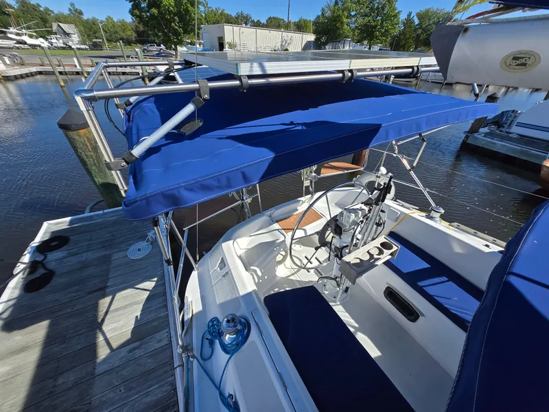 Slide: The Image of 1994 Hunter 33.5 sailboat with blue canopy docked at marina. - 27