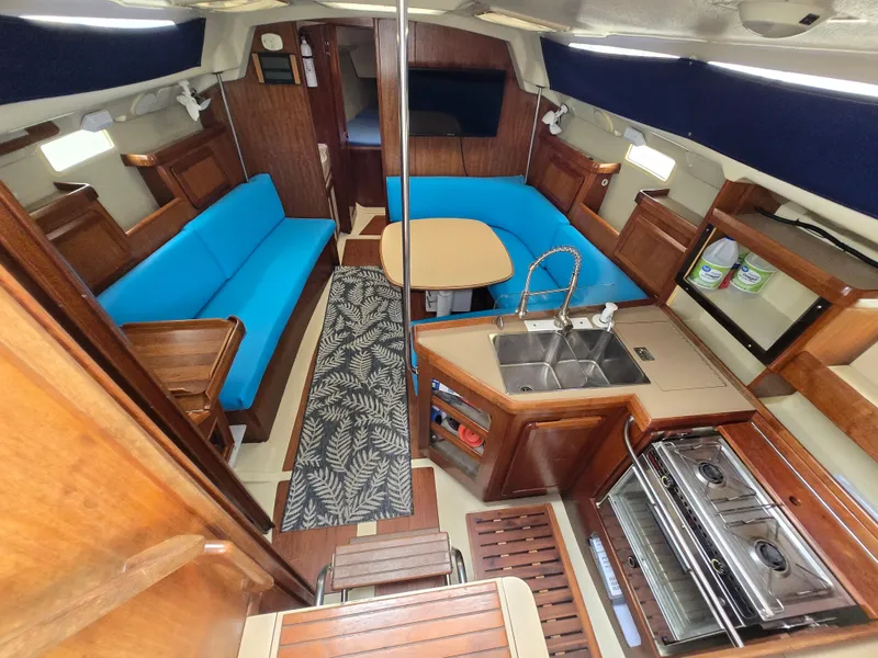 Slide: The Image of Interior of a 1994 Hunter 33.5 sailboat with blue seating and wooden cabinetry. - 3