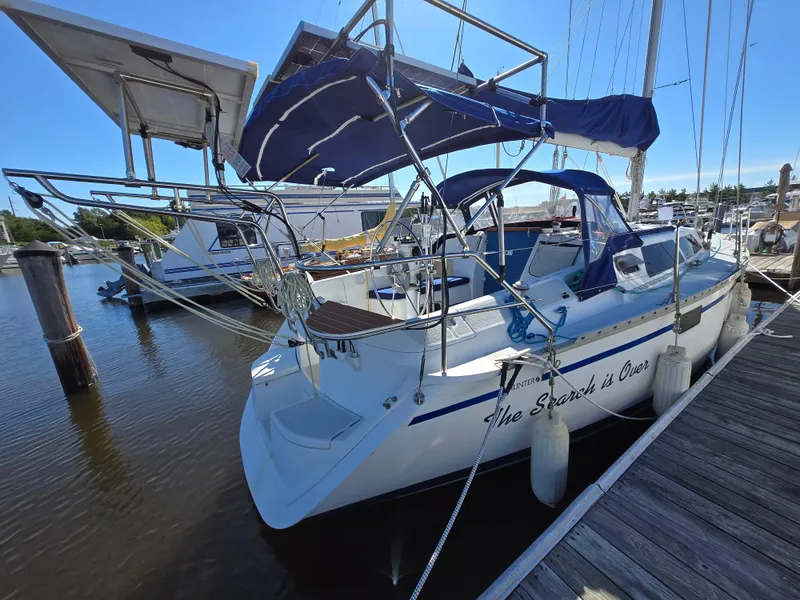 Slide: The Image of Sailboat docked at marina, 1994 Hunter 33.5 model, featuring blue canopy and white hull. - 30