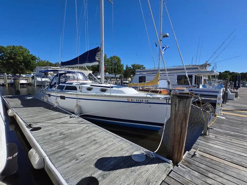 Slide: The Image of Hunter 33.5 sailboat from 1994 docked at a marina under clear blue skies. - 31