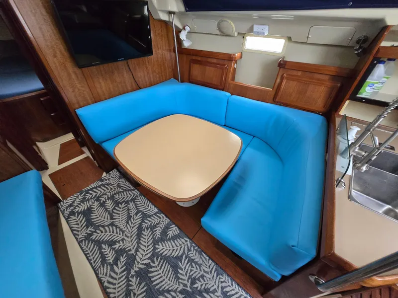 Slide: The Image of Interior of 1994 Hunter 33.5 sailboat with blue seating and wooden accents. - 35