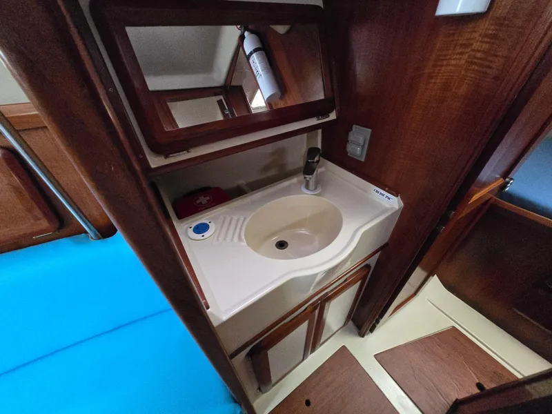 Slide: The Image of Interior of 1994 Hunter 33.5 sailboat showing compact bathroom sink and mirror. - 37