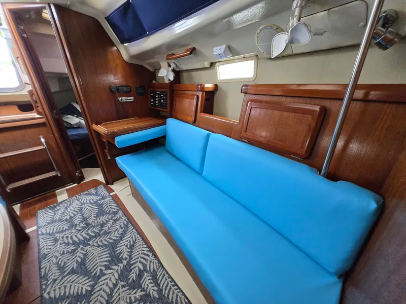 Slide: The Image of Interior of a 1994 Hunter 33.5 sailboat with blue seating and wooden cabinetry. - 39