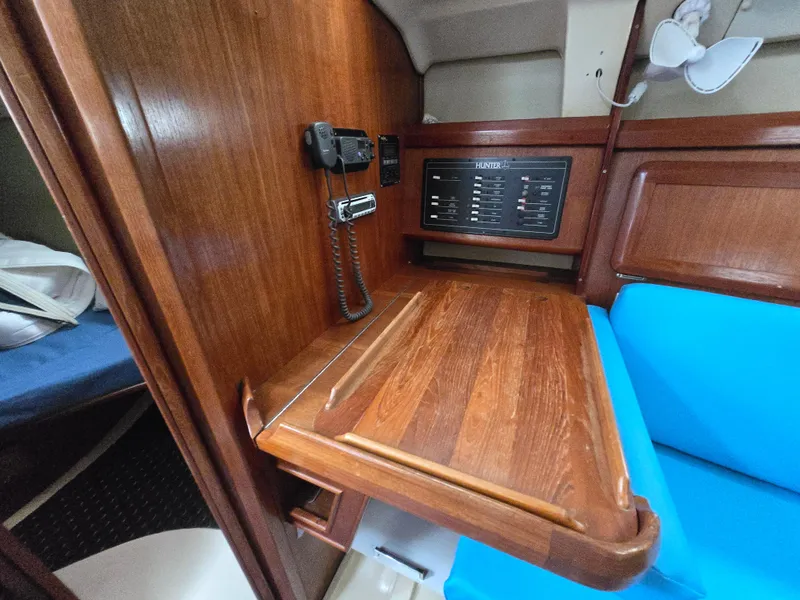 Slide: The Image of 1994 Hunter 33.5 yacht interior with wooden table, radio, and blue seating. - 40