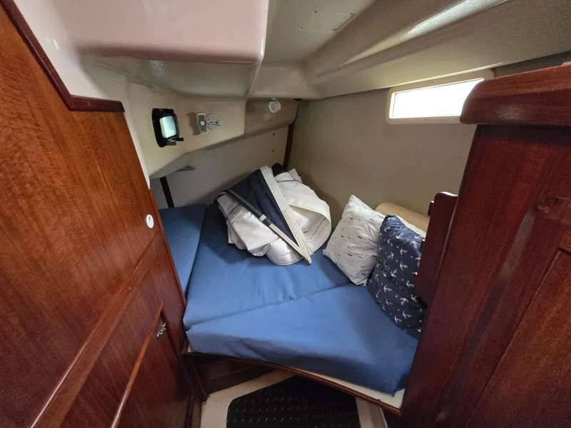 Slide: The Image of Cozy cabin interior of a 1994 Hunter 33.5 sailboat with blue bedding and wooden accents. - 41