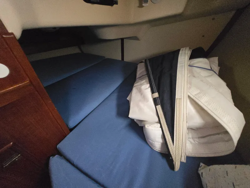 Slide: The Image of Interior cabin of a 1994 Hunter 33.5 sailboat with blue cushions and folded sails. - 42
