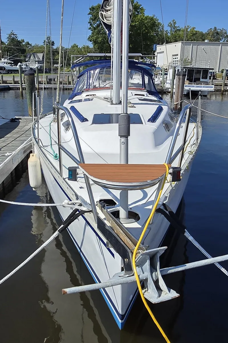 Slide: The Image of 1994 Hunter 33.5 sailboat docked at marina, front view with clear blue sky. - 9