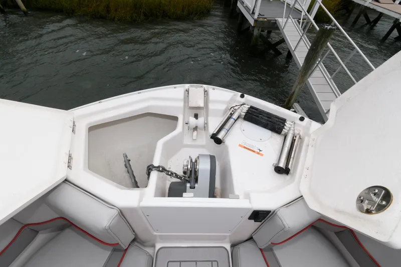 Slide: The Image of 2023 Solara S-250 DC boat anchor compartment with storage and ladder near dock. - 17