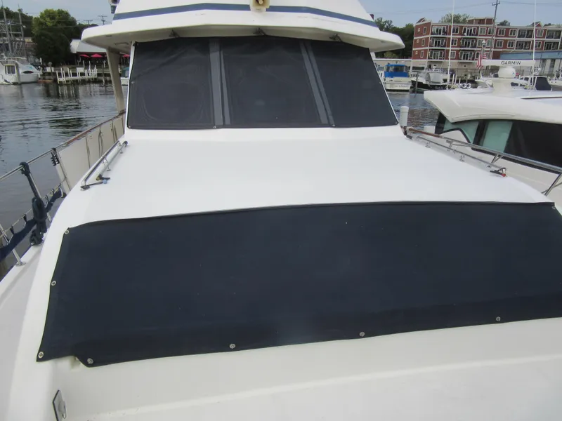 Slide: The Image of 1990 Jefferson Marquessa 52 yacht docked at marina, featuring covered deck area. - 32