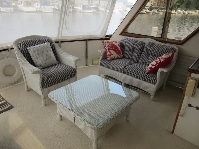 Slide: The Image of Cozy seating area on a 1990 Jefferson Marquessa 52 yacht with wicker furniture and marina view. - 37