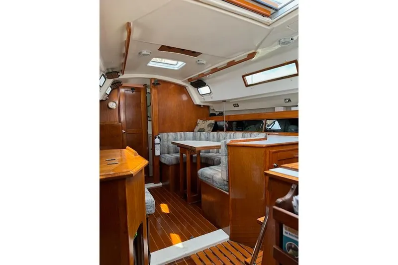 Slide: The Image of Interior of a 1987 Hunter 31 sailboat with wooden furnishings and seating area. - 10