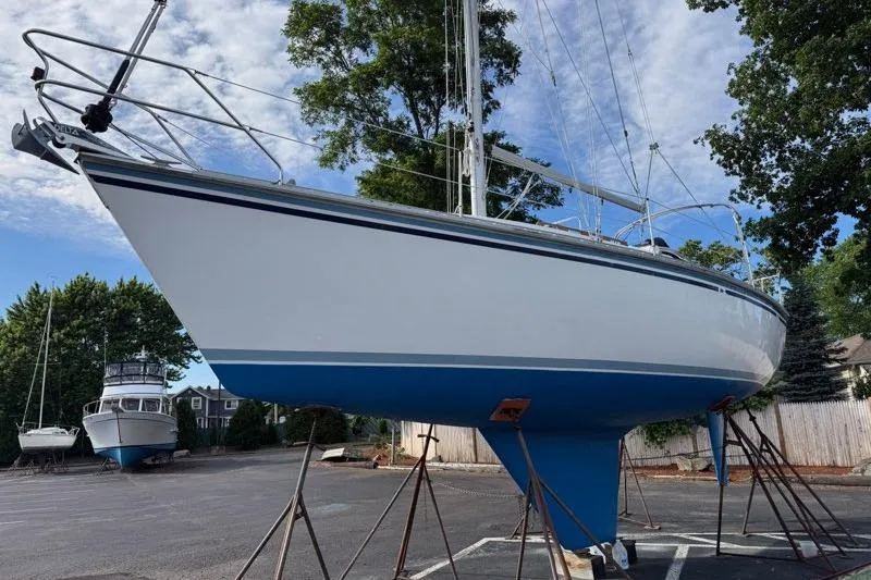 Slide: The Image of 1987 Hunter 31 sailboat on stands, ready for maintenance in a boatyard. - 4