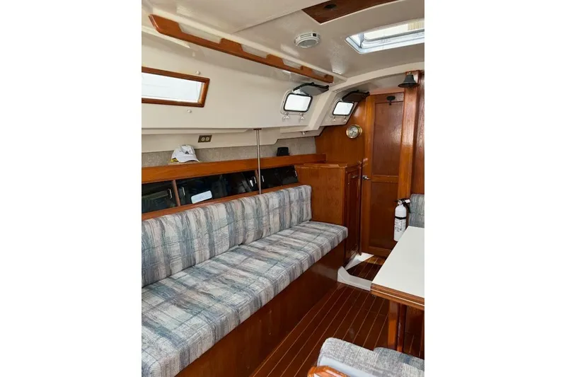 Slide: The Image of Interior of 1987 Hunter 31 sailboat with wood finish and cushioned seating. - 6