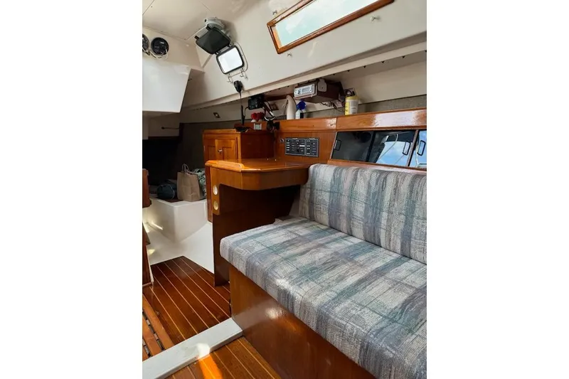 Slide: The Image of Interior of a 1987 Hunter 31 sailboat with wood accents and plaid seating. - 7