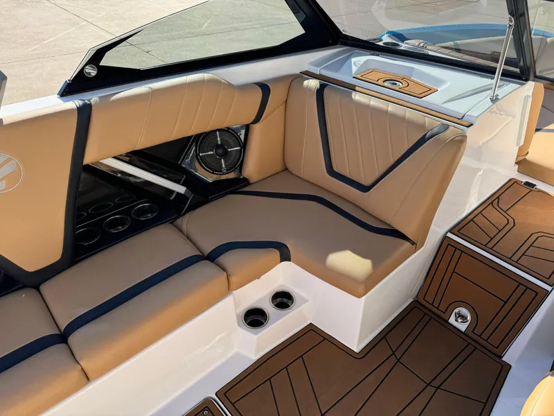 Slide: The Image of 2020 Tigé 23 RZX boat interior with tan and black seating, cup holders, and speaker. - 13