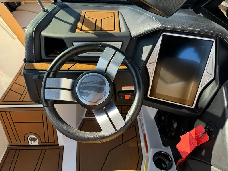 Slide: The Image of 2020 Tigé 23 RZX boat dashboard with steering wheel and touchscreen display. - 14