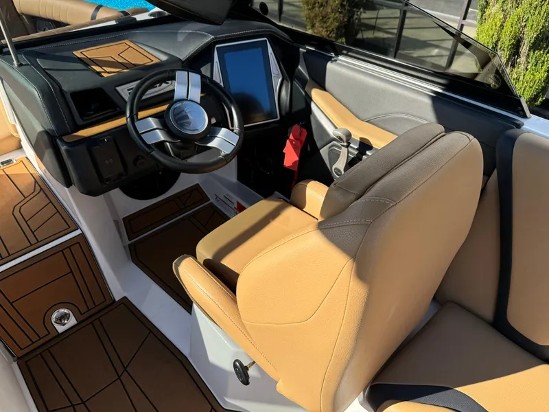 Slide: The Image of 2020 Tigé 23 RZX boat interior with tan seats and modern dashboard. - 18
