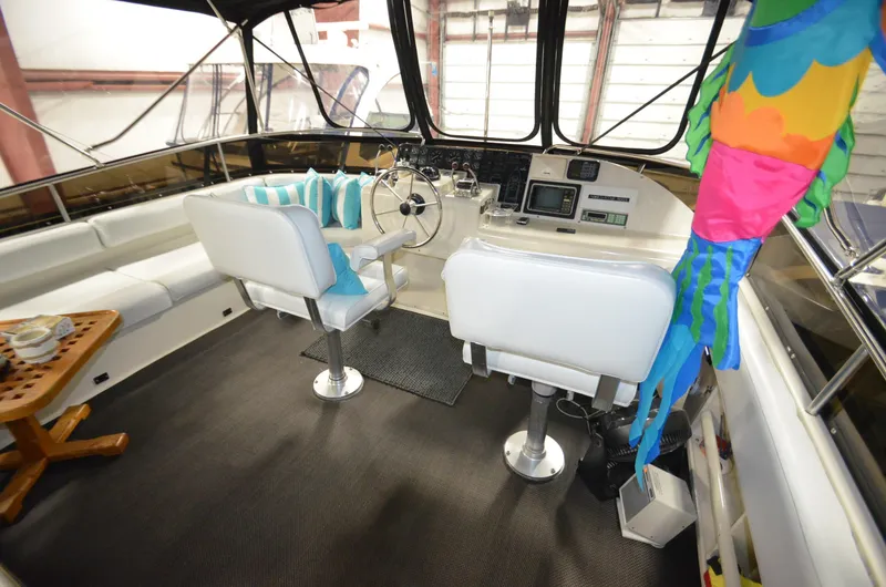 Slide: The Image of 1989 Silverton Aft Cabin 46 interior with helm, seating, and colorful decor. - 25