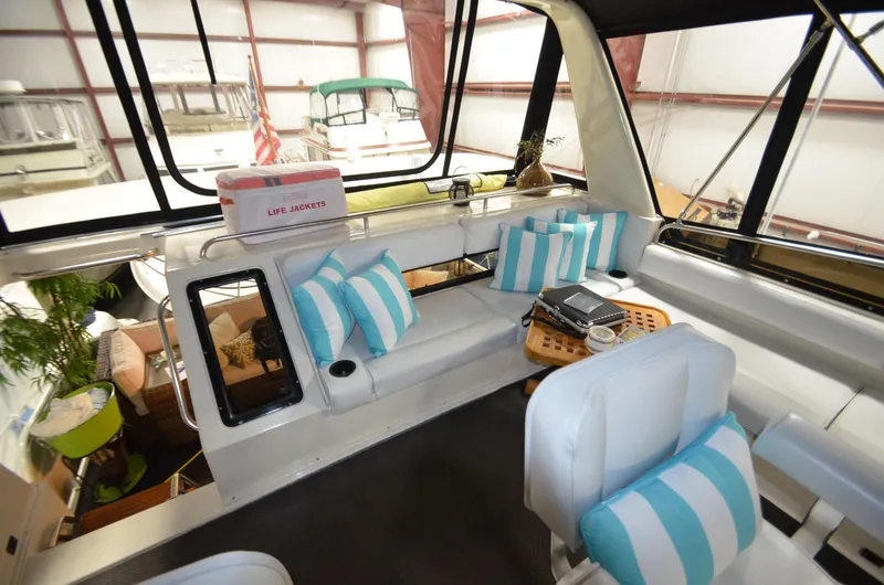 Slide: The Image of 1989 Silverton Aft Cabin 46 interior with striped cushions and life jackets, docked indoors. - 27