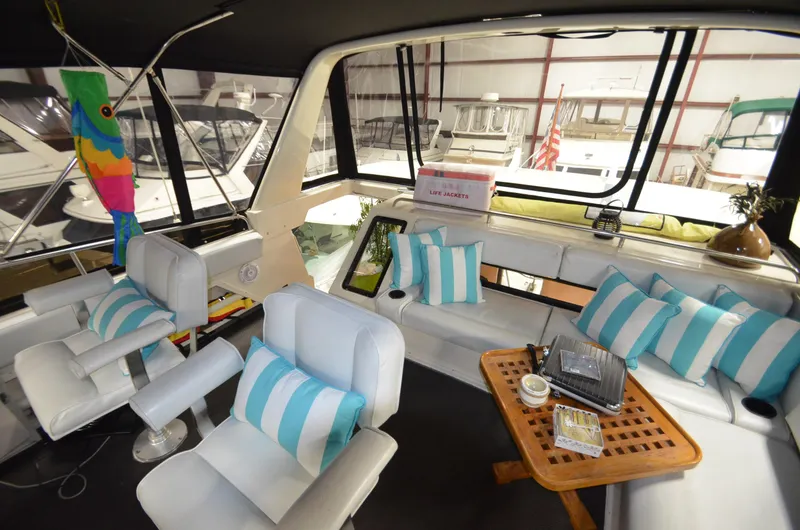 Slide: The Image of 1989 Silverton Aft Cabin 46 interior with striped cushions and seating in a marina setting. - 31