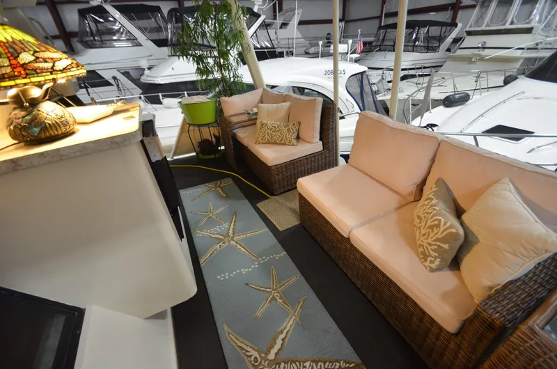 Slide: The Image of 1989 Silverton Aft Cabin 46 interior with cozy seating and nautical decor in a marina setting. - 34