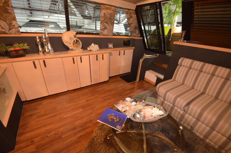 Slide: The Image of 1989 Silverton Aft Cabin 46 interior with striped sofa, wooden flooring, and decorative accents. - 4