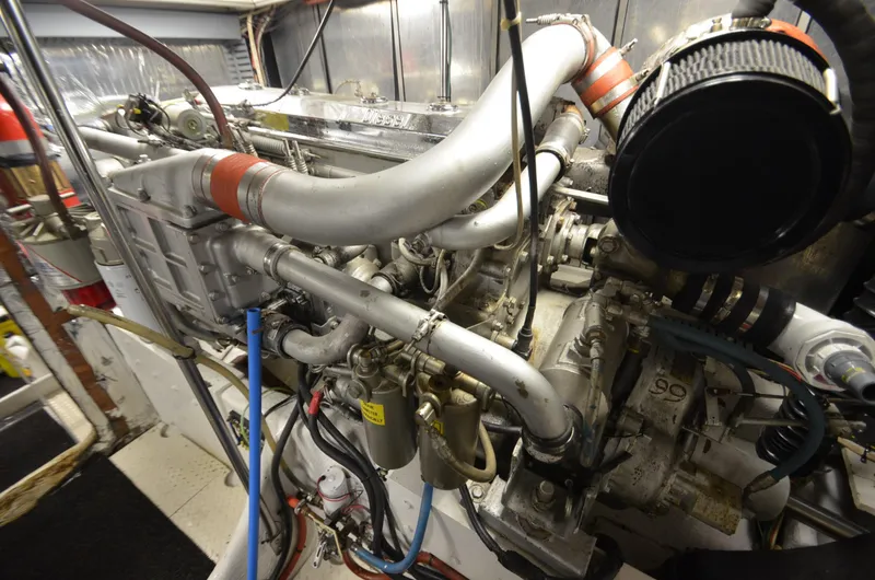 Slide: The Image of Engine room of 1989 Silverton Aft Cabin 46 yacht, showcasing complex machinery and piping. - 40