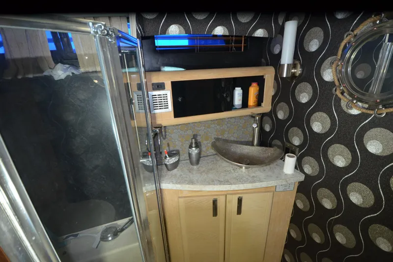 Slide: The Image of 1989 Silverton 46 Aft Cabin bathroom with modern sink and patterned wallpaper. - 44