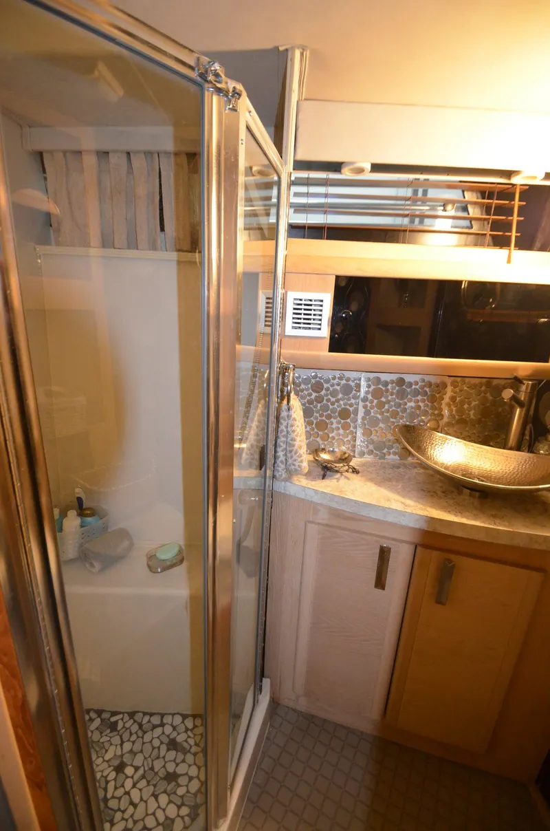 Slide: The Image of 1989 Silverton Aft Cabin 46 bathroom with shower, vessel sink, and modern fixtures. - 45