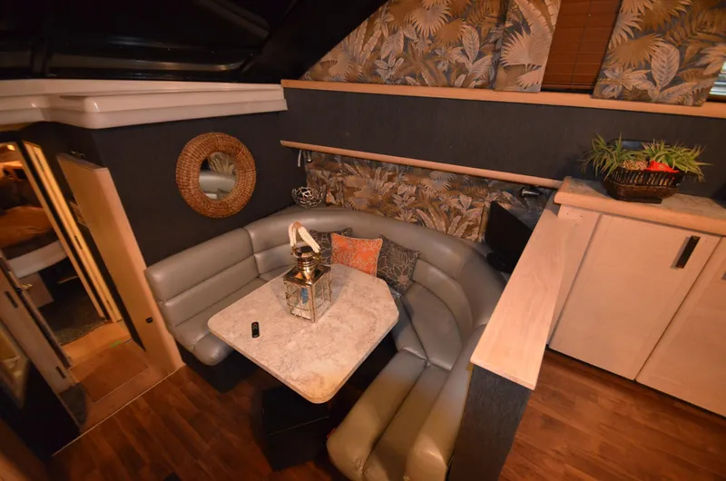 Slide: The Image of 1989 Silverton Aft Cabin 46 interior with cozy seating, table, and decorative accents. - 5