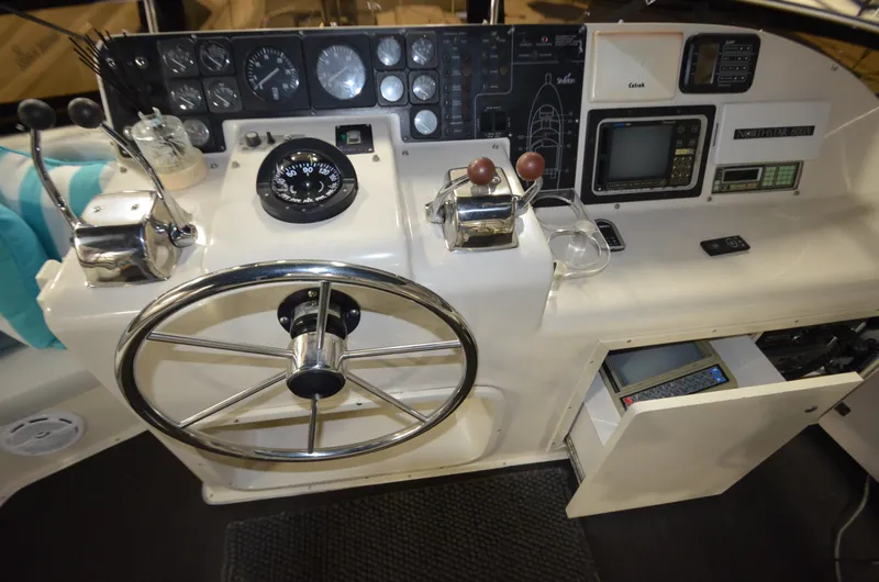 Slide: The Image of 1989 Silverton Aft Cabin 46 helm with steering wheel and navigation instruments. - 50