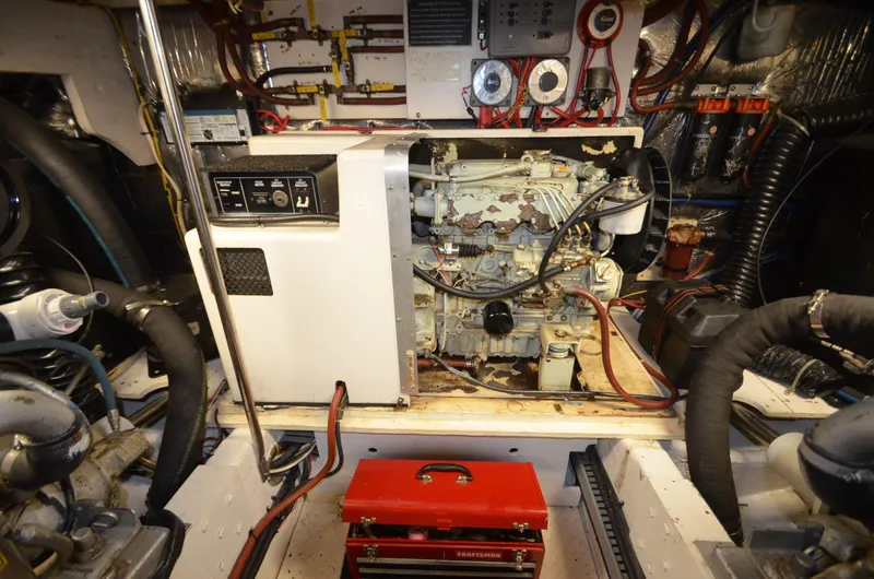 Slide: The Image of Engine room of 1989 Silverton Aft Cabin 46 with visible machinery and red toolbox. - 54