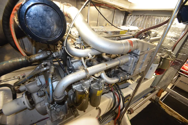 Slide: The Image of Engine room of 1989 Silverton Aft Cabin 46 yacht, showcasing complex machinery and components. - 58