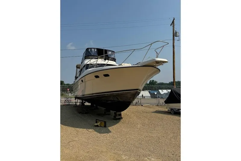 Slide: The Image of 1989 Silverton 46 Aft Cabin yacht on dry land, under clear blue sky. - 61