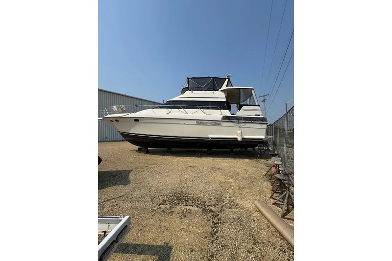 Slide: The Image of 1989 Silverton 46 Aft Cabin yacht on dry dock, side view, clear sky background. - 64