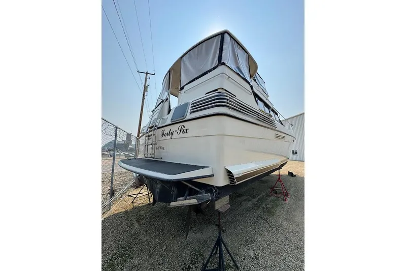 Slide: The Image of 1989 Silverton 46 Aft Cabin yacht on stands, rear view, in a boatyard. - 67
