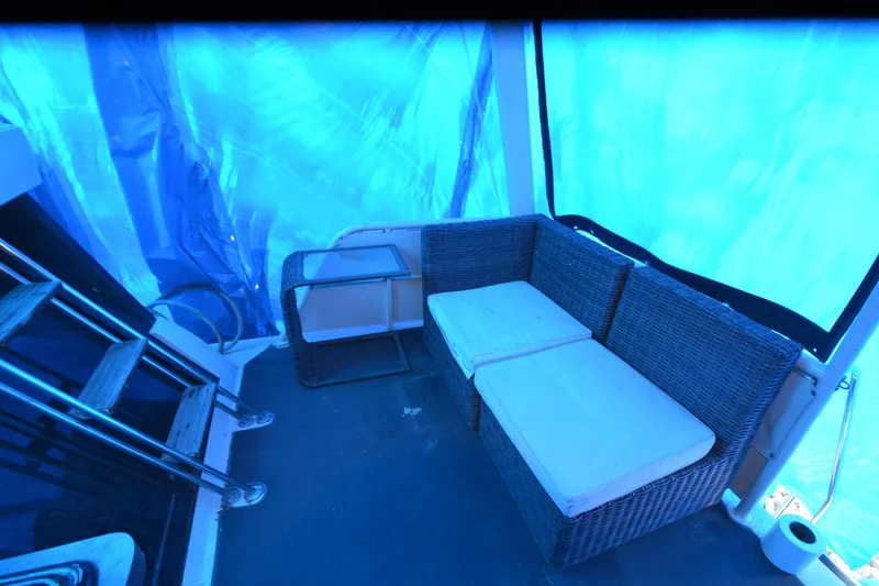 Slide: The Image of 1989 Silverton 46 Aft Cabin interior with wicker seating and blue tarp cover. - 68