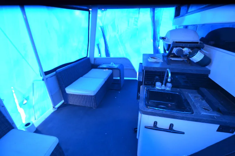 Slide: The Image of 1989 Silverton 46 Aft Cabin interior with kitchenette and seating area under blue lighting. - 70