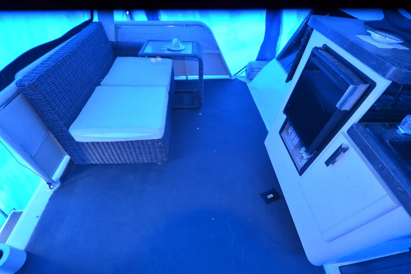 Slide: The Image of Interior of 1989 Silverton 46 Aft Cabin with wicker seating and kitchenette. - 73