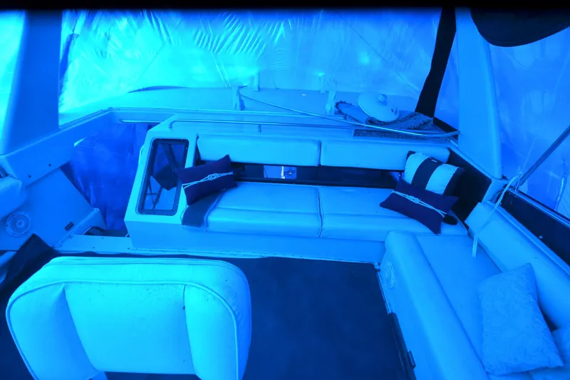 Slide: The Image of Interior of 1989 Silverton 46 Aft Cabin yacht with blue lighting and cushioned seating. - 77