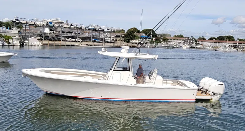 Slide: The Image of 2023 Regulator 34 boat on calm water near marina. - 1