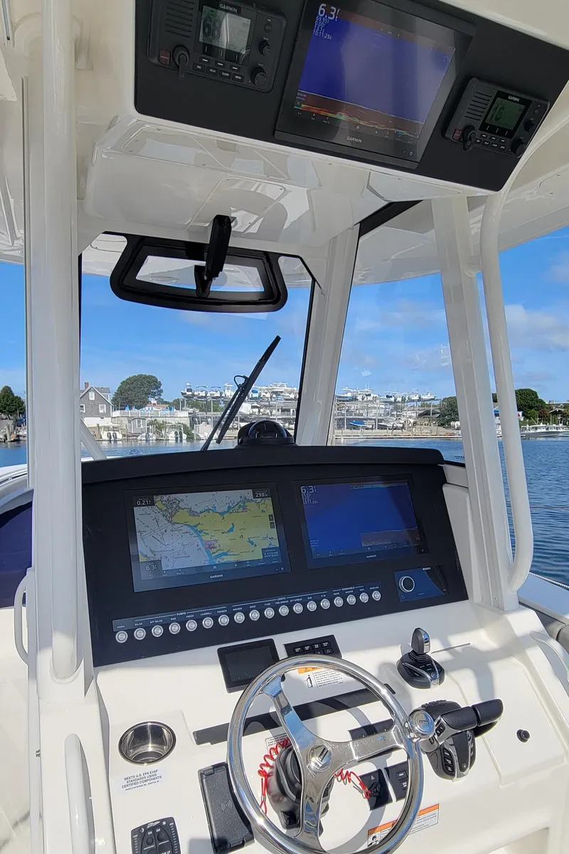 Slide: The Image of 2023 Regulator 34 boat dashboard with advanced navigation systems and steering wheel. - 10