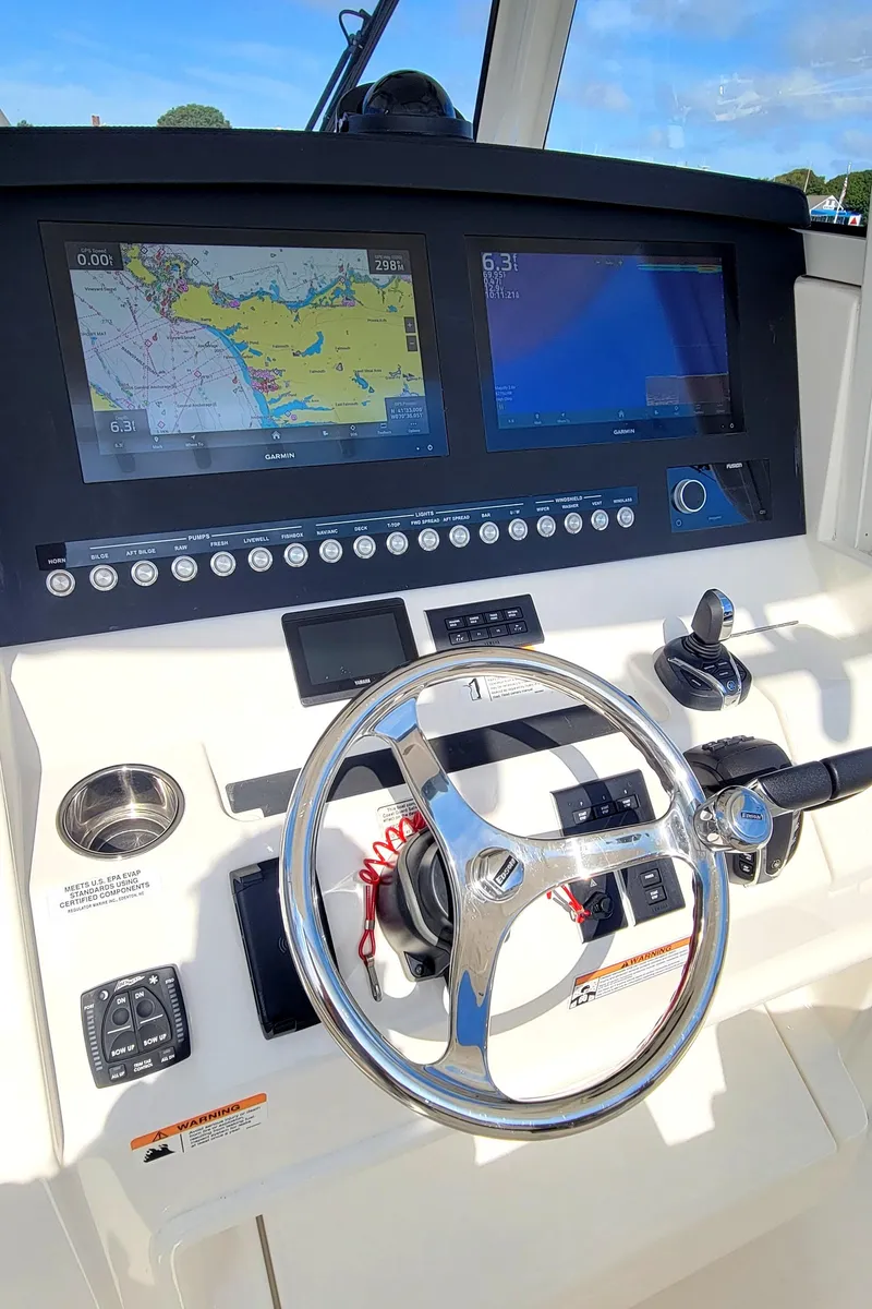 Slide: The Image of 2023 Regulator 34 boat helm with dual navigation screens and steering wheel. - 11