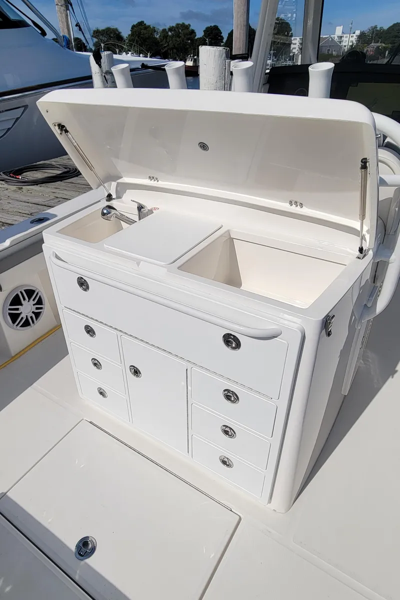 Slide: The Image of 2023 Regulator 34 boat with open storage compartment and drawers on deck. - 14