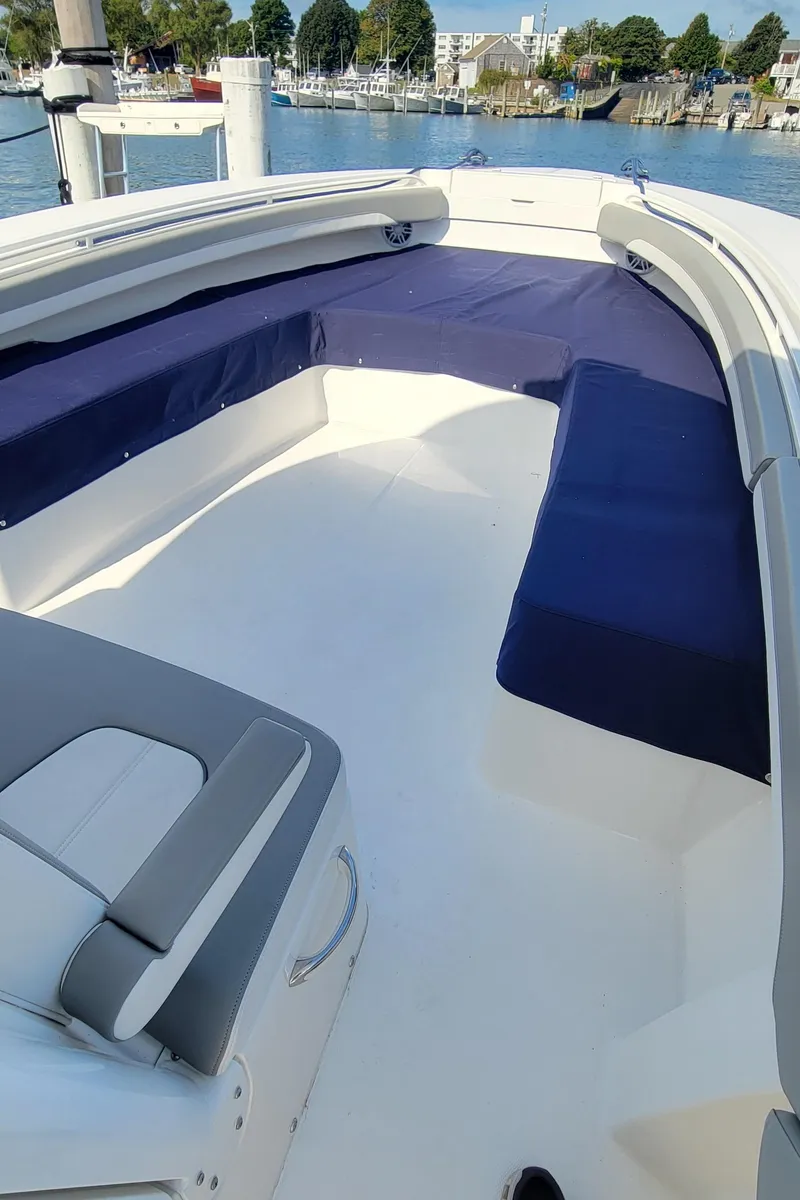 Slide: The Image of 2023 Regulator 34 boat with spacious seating, docked by the waterfront. - 23