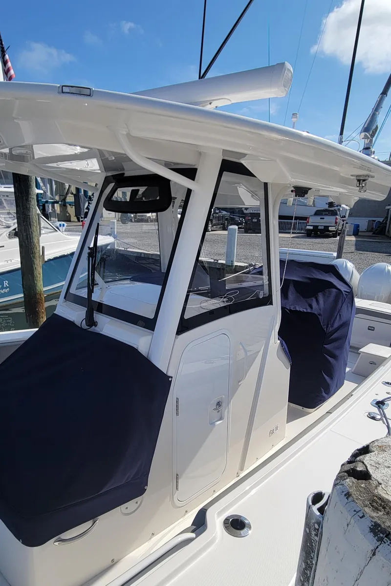 Slide: The Image of 2023 Regulator 34 boat with covered seating, docked under a clear blue sky. - 25