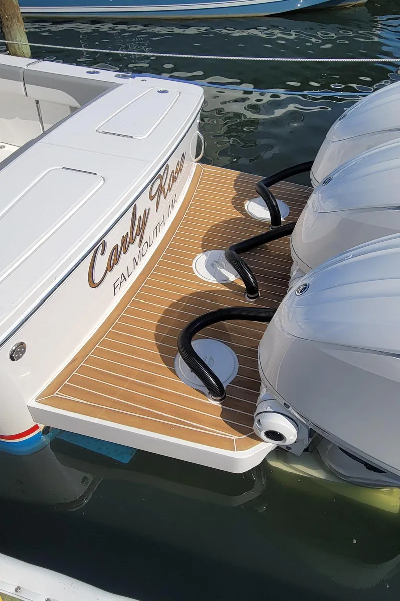 Slide: The Image of 2023 Regulator 34 boat with dual engines and teak deck, docked in water. - 4