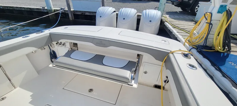 Slide: The Image of 2023 Regulator 34 boat with triple engines, docked with visible seating and deck area. - 6