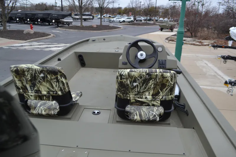 Slide: The Image of 2025 Tracker Grizzly 1754 SC boat with camo seats and steering console. - 2