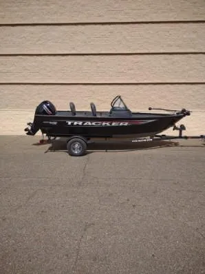 Slide: The Image of 2025 Tracker Pro Guide V-16 WT boat on trailer, parked against a beige wall. - 4